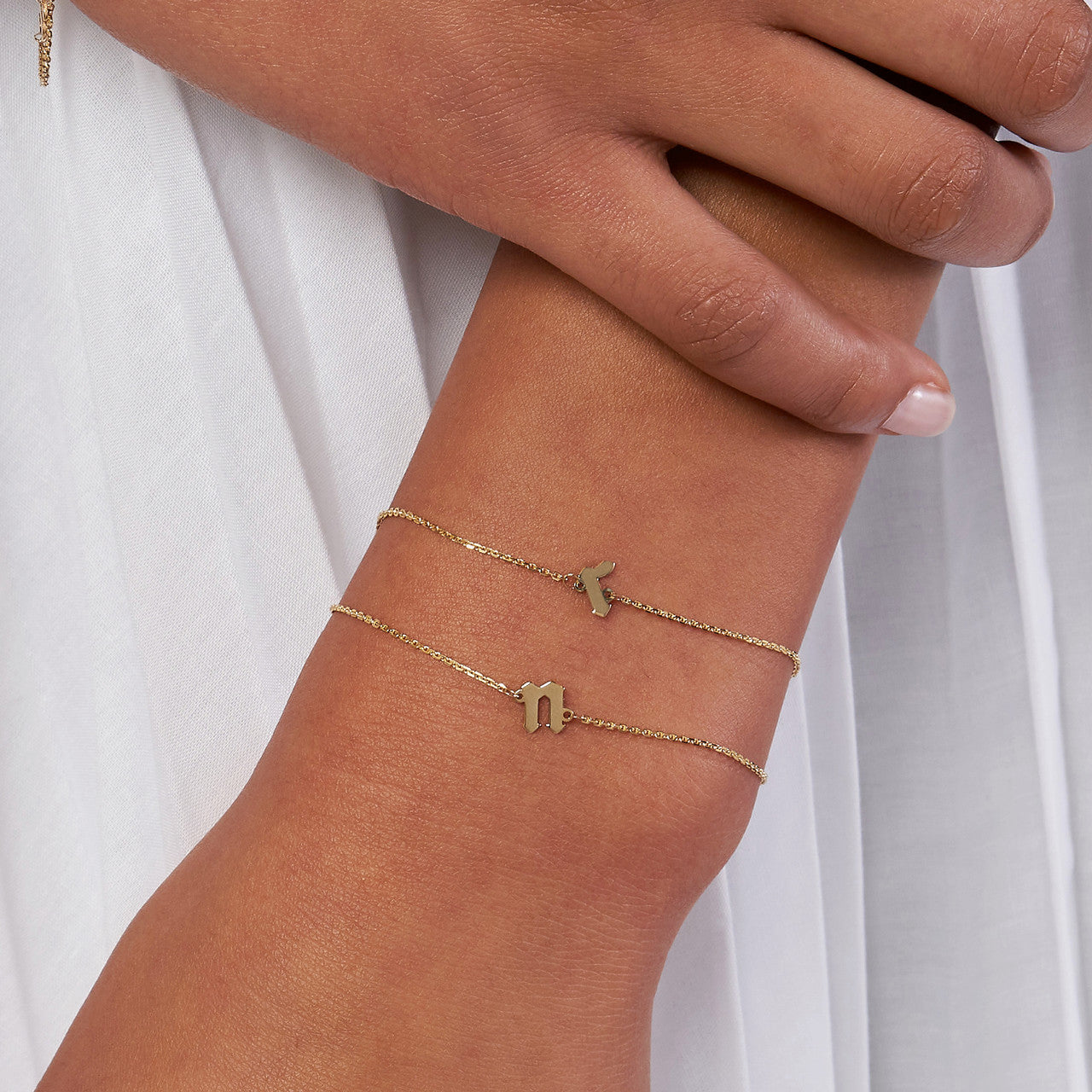 woman wearing two Slanted Gothic Initial Bracelet with the initials N and R