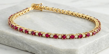 14k gold tennis bracelet with alternating rubies and diamonds.