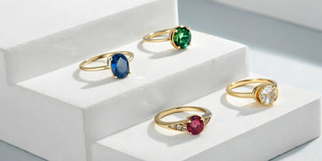 A collection of custom birthstone rings for mothers in various styles with colorful gemstones.