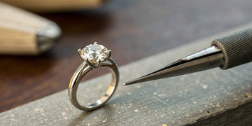 A jeweler inspects the prongs on a diamond ring for repair.