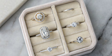 A selection of the best diamond anniversary rings for her displayed in a velvet jewelry box.