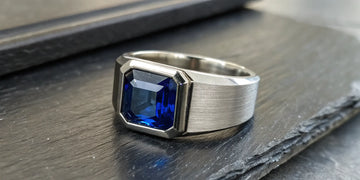Sleek silver men's ring with a rectangular blue sapphire.