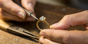 A jeweler sets a diamond in a custom engagement ring designed online.