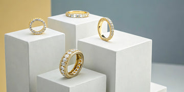Yellow gold diamond eternity bands with various settings.