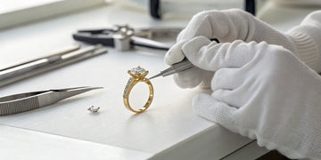 Jeweler resizing a gold diamond ring with precision tools to avoid damage.
