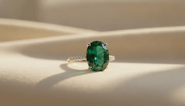 Elegant green emerald ring on a cream jewelry surface