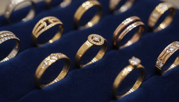 Elegant gold jewelry rings and bands in different karat shades on dark velvet
