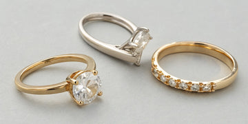 A variety of gold and diamond rings, showing designs that influence the half shank ring repair cost.