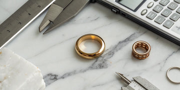 A gold ring and sizer with a calculator to determine the cost of ring resizing.