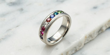 Custom birthstone wedding band with a mix of colorful gems in a silver setting.