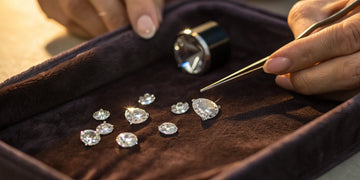 Designing a custom engagement ring by selecting your own loose diamonds with tweezers.