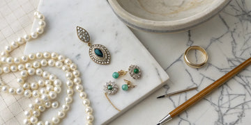 Old jewelry like a ring, pendant, and pearls ready to be redesigned.