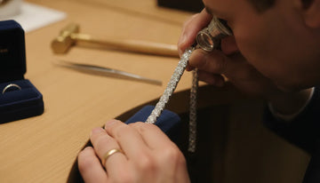 Jeweler examining a diamond tennis bracelet for authenticity clues