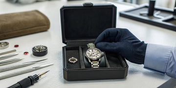 Omega watch repair specialist servicing a luxury timepiece with precision tools.