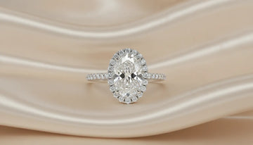 Oval diamond engagement ring on ivory silk