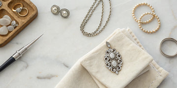 Old jewelry and jeweler's tools laid out for a custom redesign project.