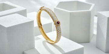 Gold Roberto Coin bracelet with diamonds and a ruby, key details affecting its price.