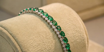 Emerald tennis bracelet with alternating emeralds and diamonds.