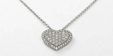 A sparkling pave diamond heart pendant on a white gold necklace.
