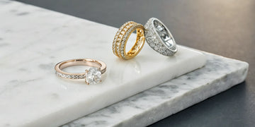 Gold and platinum diamond pinky rings with solitaire and pavé settings.
