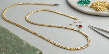 Gold and gemstones on a Roberto Coin necklace, key factors that determine its price.