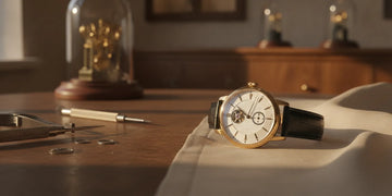 Close view of an elegant mechanical wristwatch with its dial and case details in soft natural light