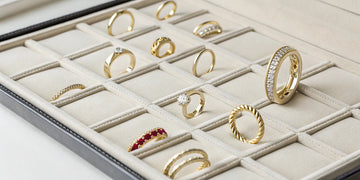 Gold, diamond, and gemstone Roberto Coin rings on sale inside a luxury jewelry box.