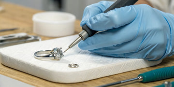 Jeweler using precision tools on a diamond ring for jewelry repair services in Oceanside, NY.