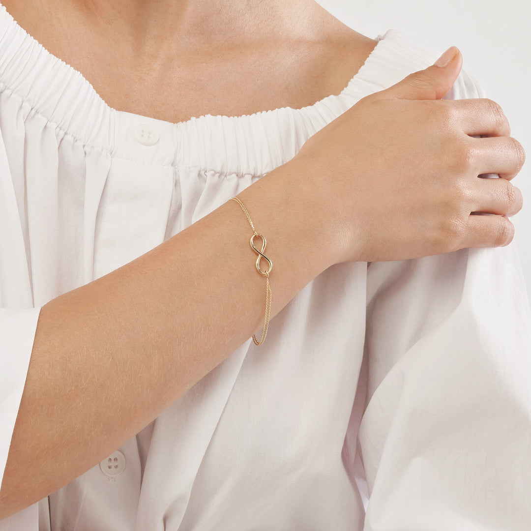woman modeling the infinity symbol on the double strand adjustable bracelet