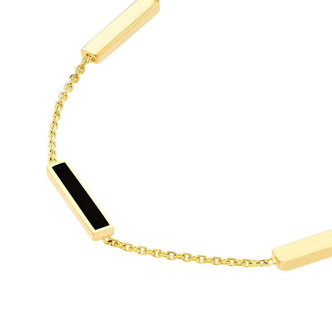 close-up of the black enamel bar on the yellow gold bracelet