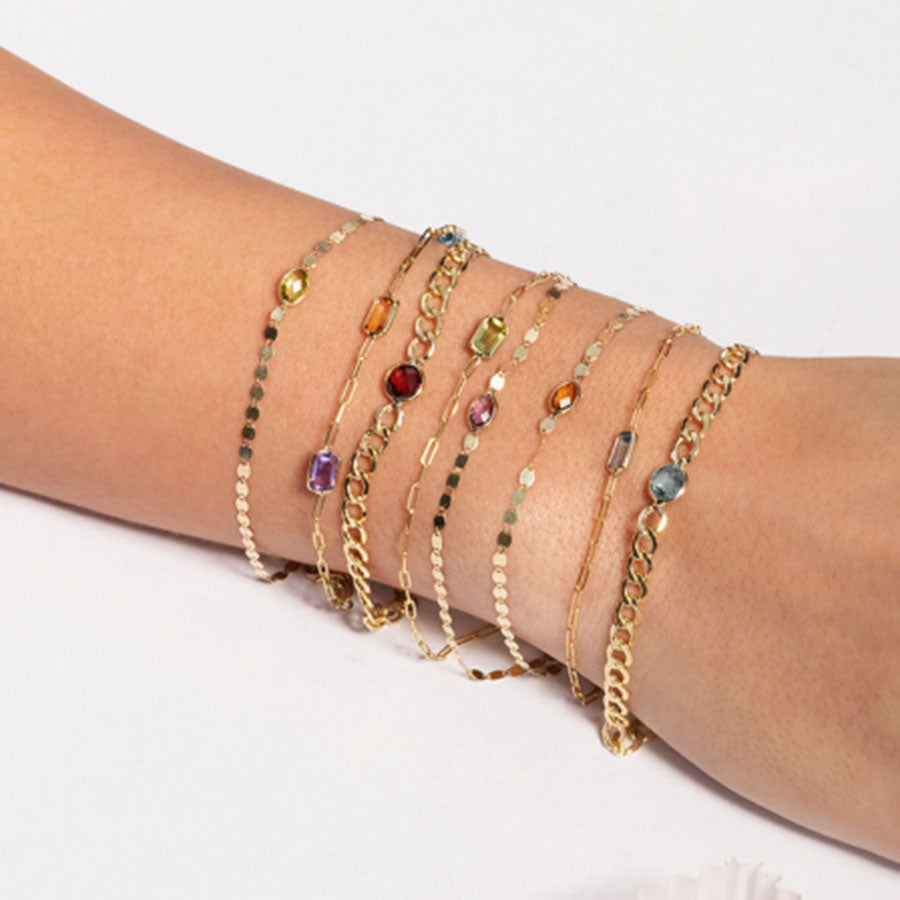 woman wearing the Peridot Paperclip Bracelet and other gem bracelets on her wrist
